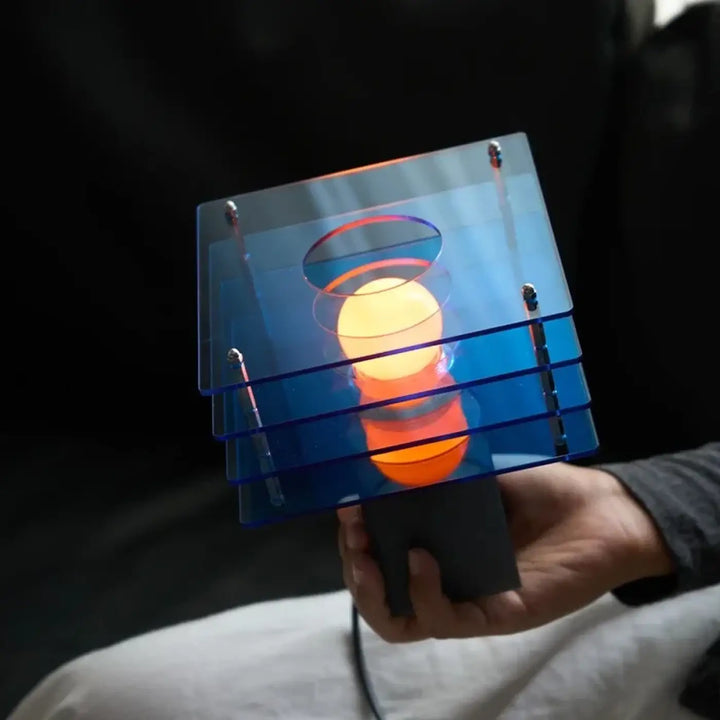 Lampe de chevet design moderne en acrylique bleu translucide avec une lueur orange chaude pour ambiance cosy
