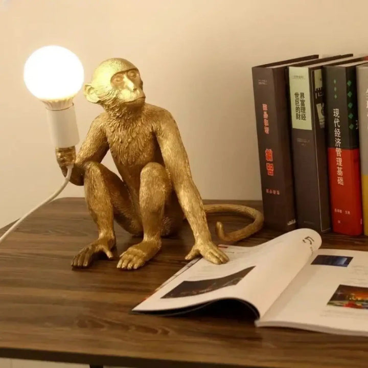 Lampe de chevet kapok figurine singe doré en métal texturé tenant une lumière douce pour une décoration intérieure moderne