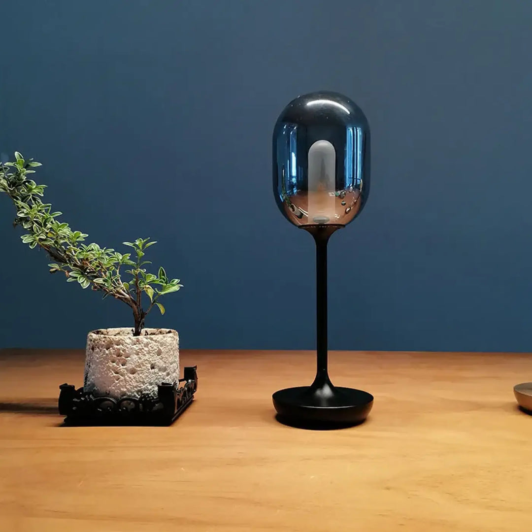 Lampe de chevet en verre moderne bleu avec tige et base noire offrant une lumière douce pour une ambiance chaleureuse