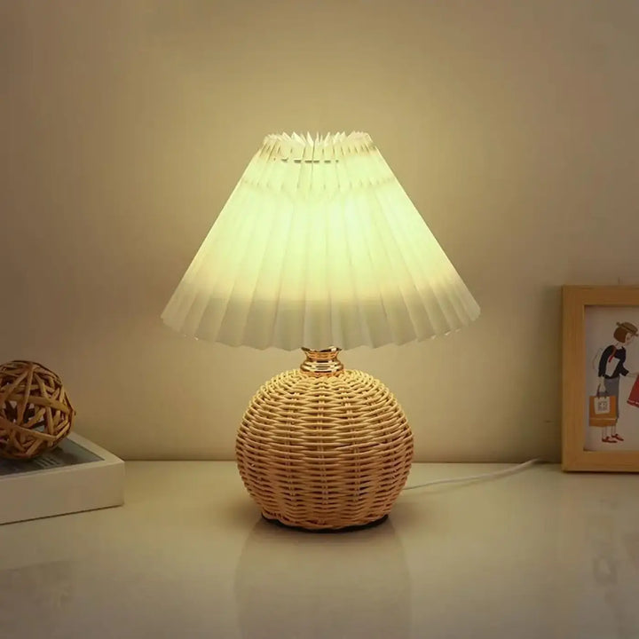 Lampe de table plipa avec abat-jour blanc plissé, base en rotin tressé rond et col finition or pour décoration intérieure design