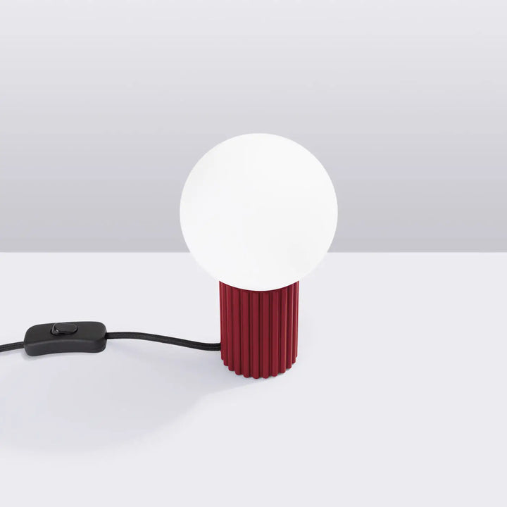Lampe a poser halo bordeaux avec base bordeaux cannelée et abat-jour sphérique blanc reliés par cordon noir avec interrupteur