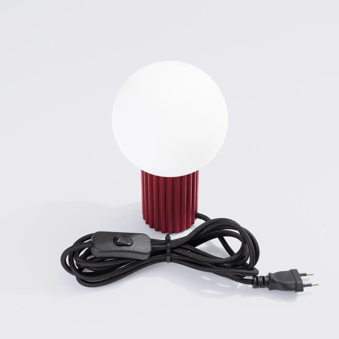 Lampe a poser halo bordeaux avec abat-jour sphérique en verre opalin et base cylindrique texturée rouge bordeaux