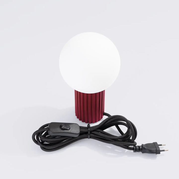 Lampe a poser halo bordeaux avec abat-jour sphérique en verre opalin et base cylindrique texturée rouge bordeaux