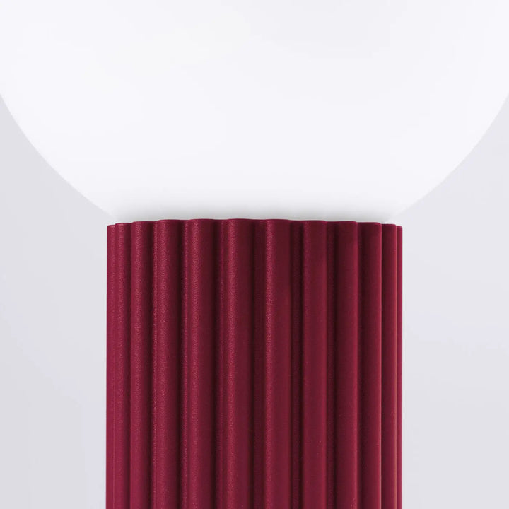 Lampe a poser halo bordeaux avec abat-jour sphérique en verre blanc et pied métallique bordeaux côtelé verticalement