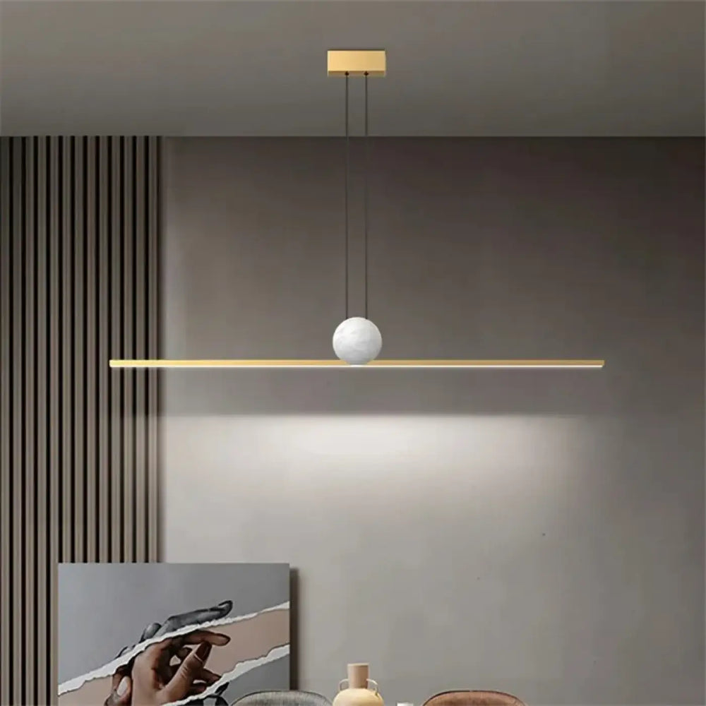 Suspension luminaire linire avec barre horizontale dorée et globe blanc mat en suspension minimaliste moderne