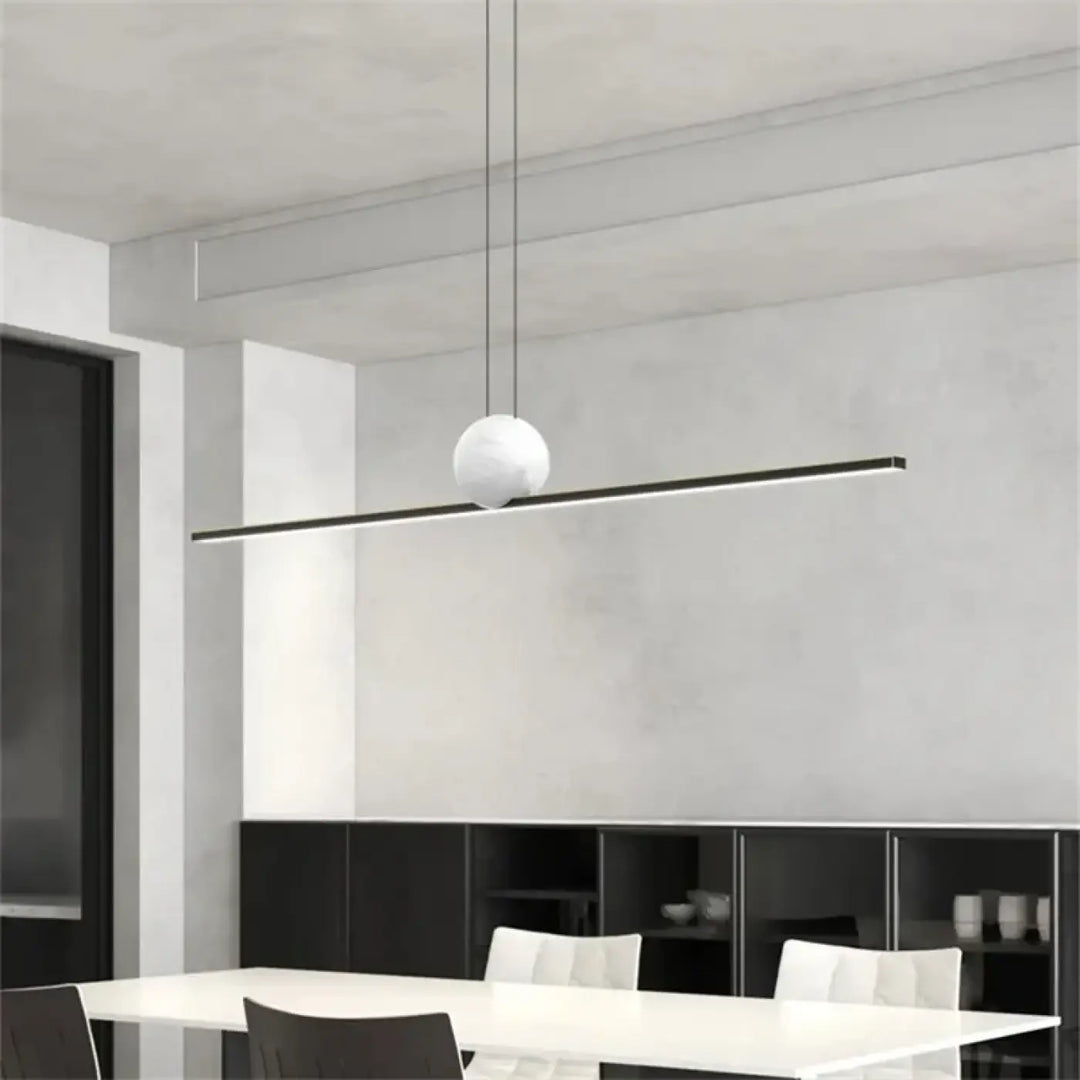 Suspension luminaire linire avec globe sphérique blanc mat suspendu à une barre linéaire noire en matériaux modernes
