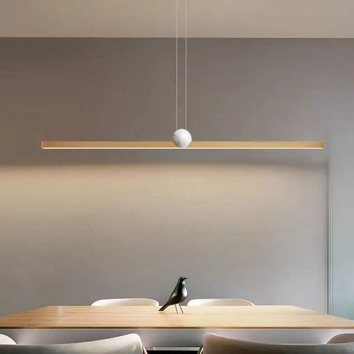 Suspension luminaire linire avec barre en bois épurée et accent sphérique blanc suspendu par des cordons fins