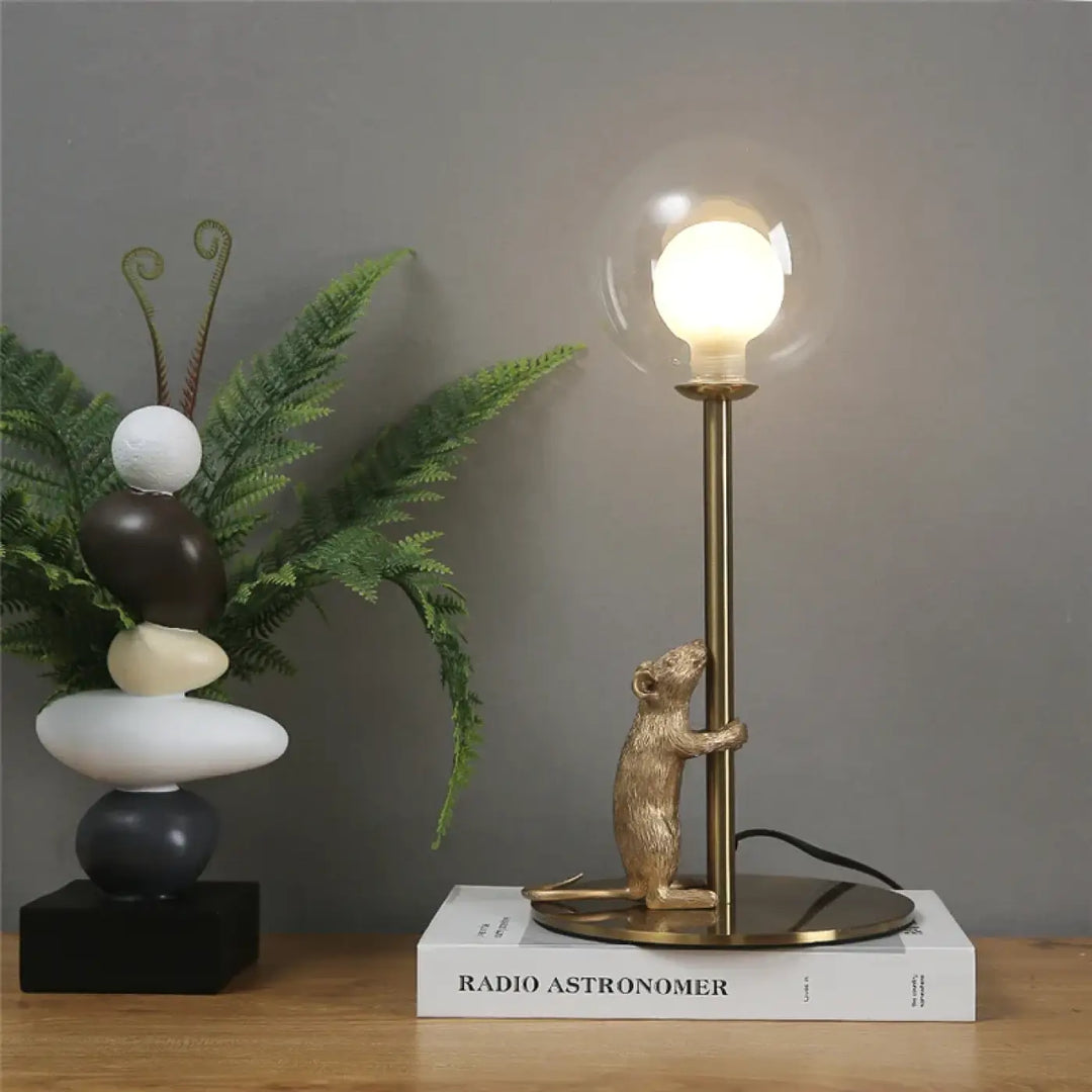 Lampe de table valavo avec souris dorée en fer type tenant un lampadaire en laiton et une ampoule sphérique lumineuse