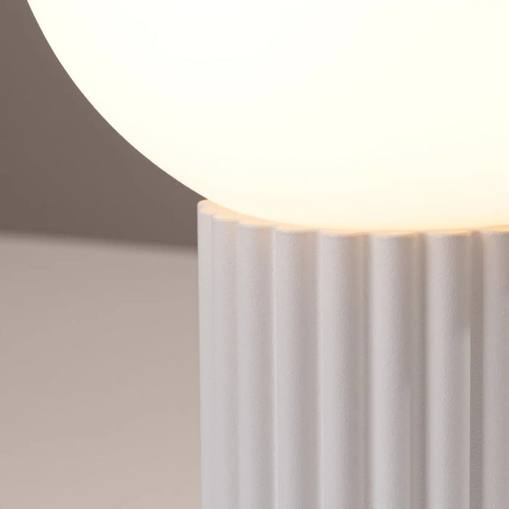 Lampe a poser halo blanc en céramique nervurée avec une boule en verre laiteux pour une réponse aux besoins déco