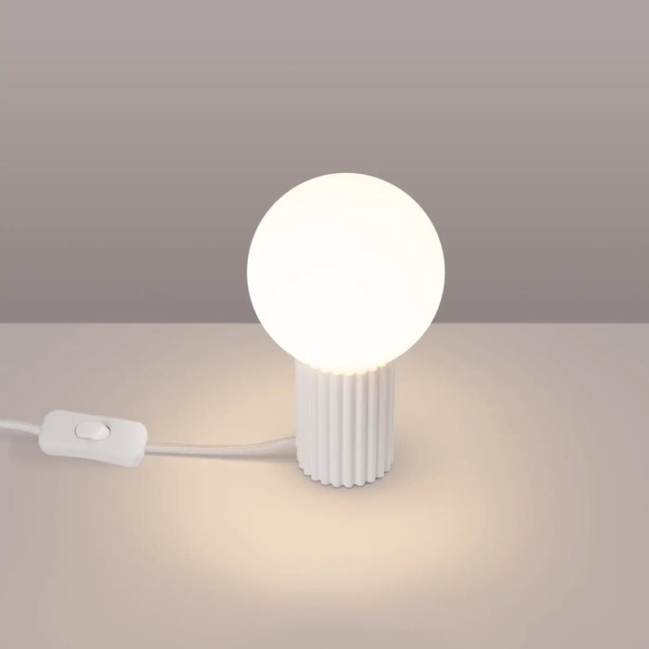 Lampe a poser halo blanc en verre laiteux avec base cylindrique nervurée émettant une lumière douce et chaude adaptée à réponse aux besoins couleurs riche
