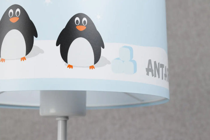 Lampe de table sweet dreams bleu clair avec abat-jour aux adorables manchots sur fond neigeux et inscription antar