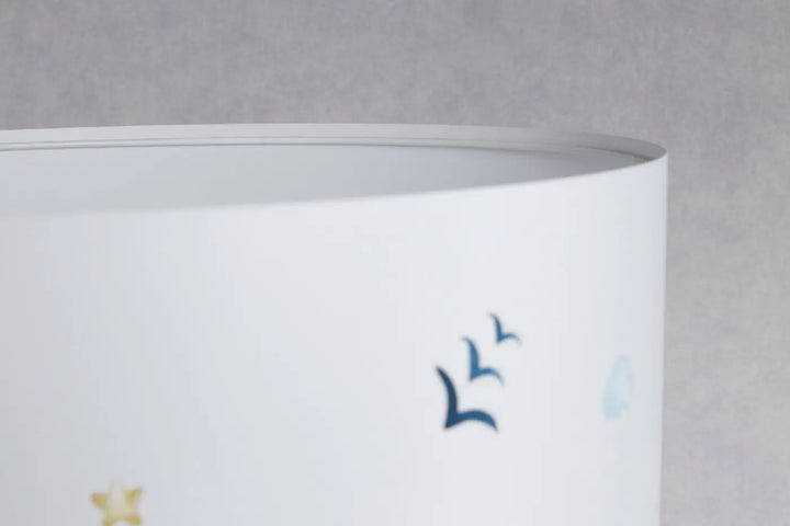 Lampe de table blanche avec abat-jour cylindrique décor oiseaux bleus subtils et étoiles dorées pour nuages rêvés