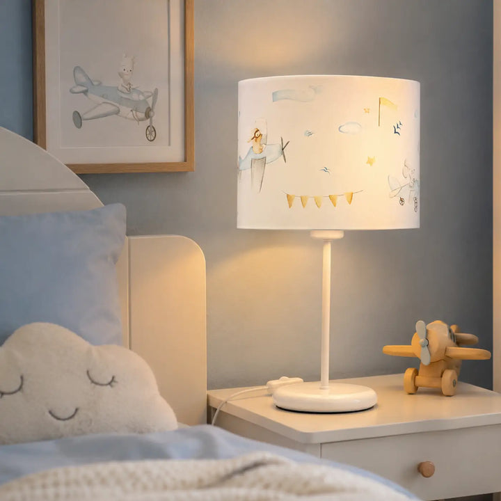 Lampe de table blanche avec abat-jour cylindrique décor avions et nuages rêvés en pastel doux bleu clair blanc
