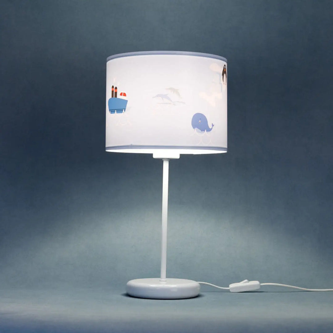 Lampe de table sweet dreams avec abat-jour cylindrique blanc illustré de baleines et manchots en décor marin doux