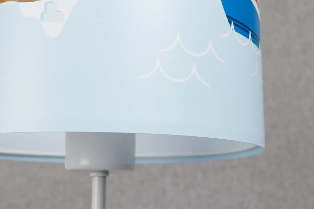 Lampe de table sweet dreams bleu clair avec abat-jour à motifs vagues blancs et décor marin doux participe à créer ambiance