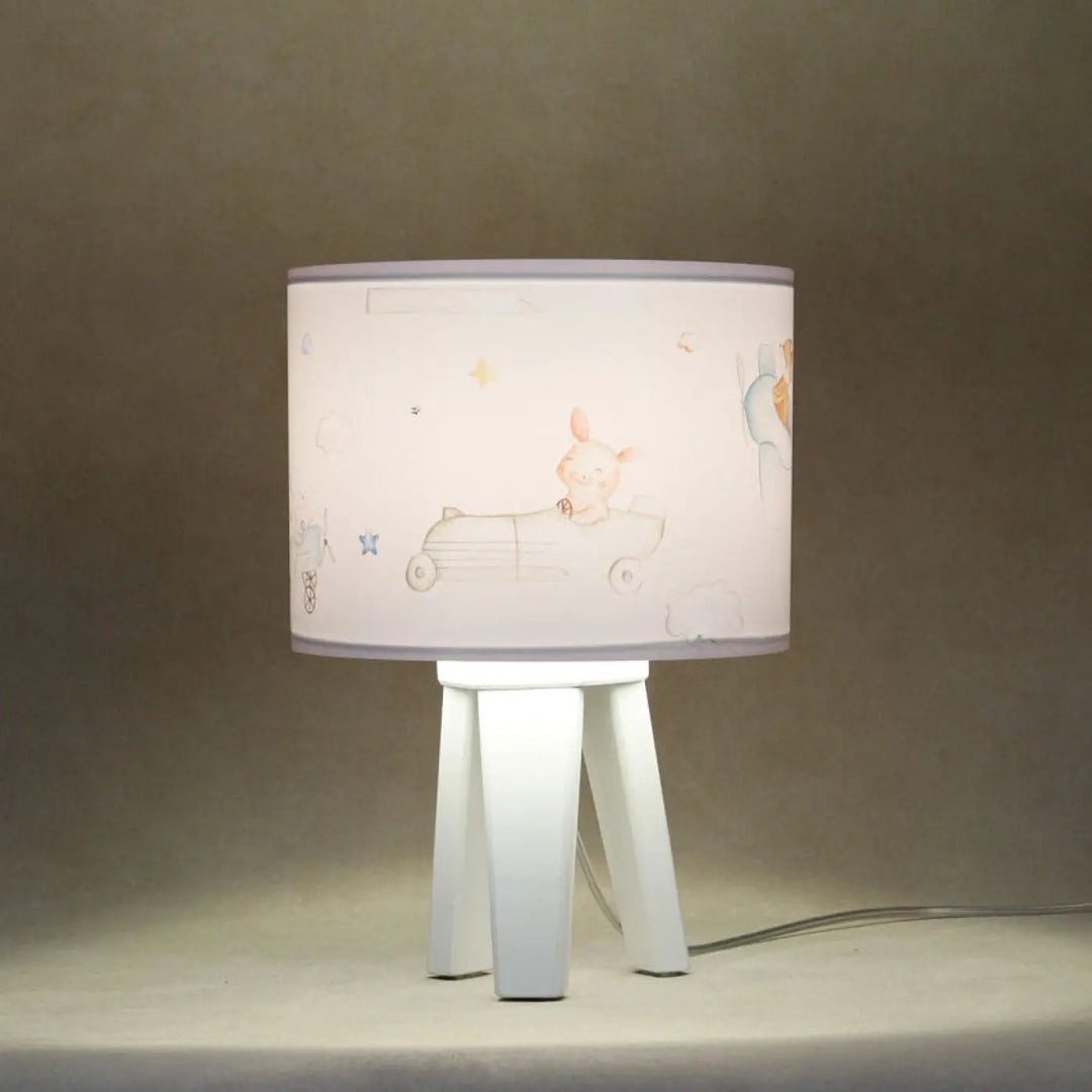Lampe de table sweet dreams blanc avec abat-jour cylindrique illustré dun lapin rose sur un fond bleu pastel sur base blanche minimaliste pour un charmant univers féerique
