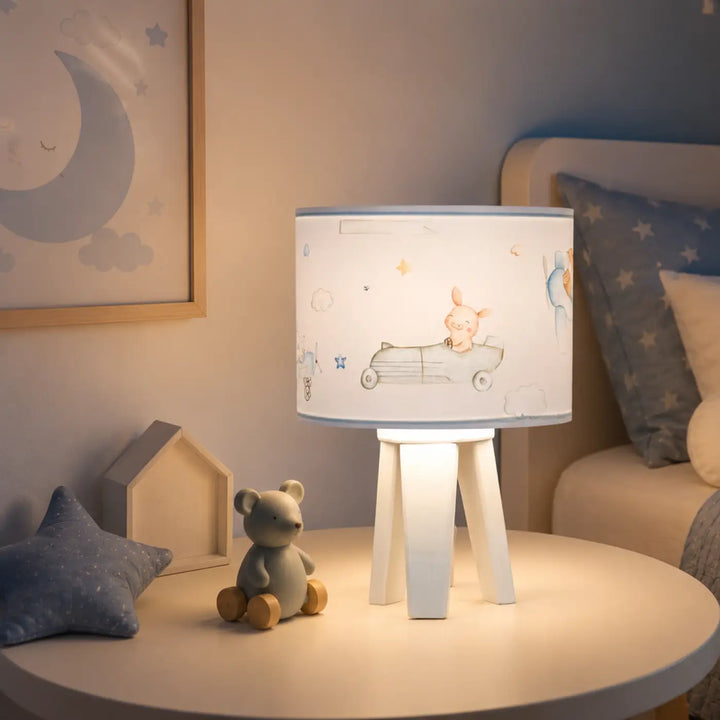 Lampe de table blanche avec abat-jour cylindre illustré d un cochon en voiture bleu pastel pour un charmant univers féerique