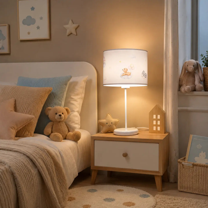 Lampe de table blanche avec abat-jour doux marron à l’ourson pleine sur pied fin posée sur une table de nuit en bois