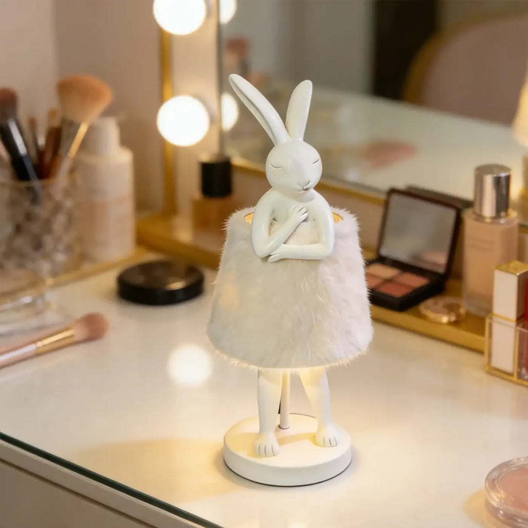 Lampe de table bunnya en porcelaine blanche avec jupe en plumes et base lumineuse pour un objet décoratif plus qu’un simple éclairage