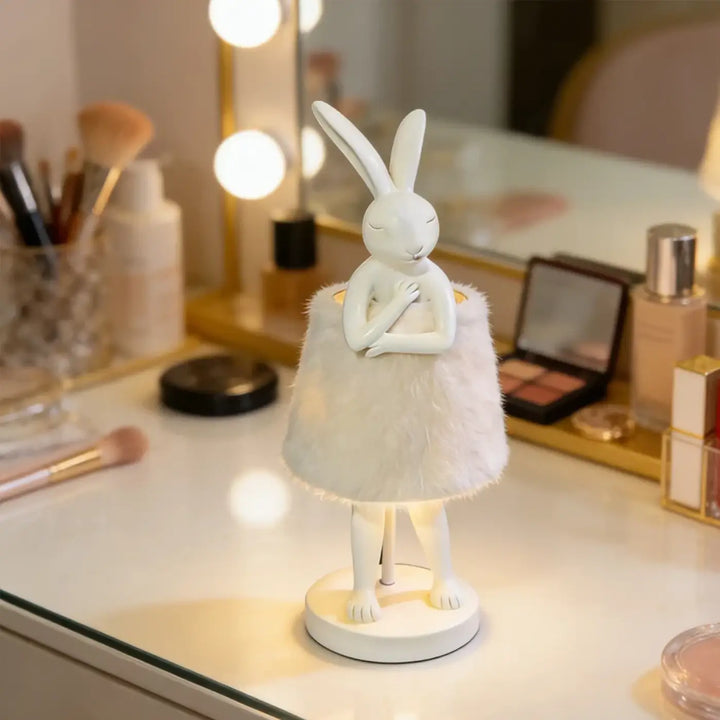 Lampe de table bunnya en porcelaine blanche avec jupe en plumes et base lumineuse pour un objet décoratif plus qu’un simple éclairage
