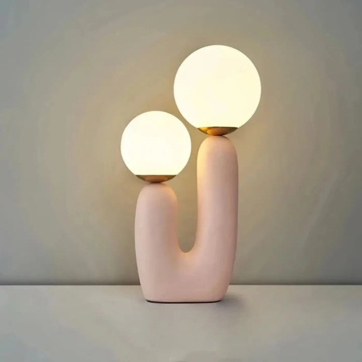Lampe de table tsilo en céramique rose pastel avec deux globes en verre lumineux et accents dorés sont-elles incluses