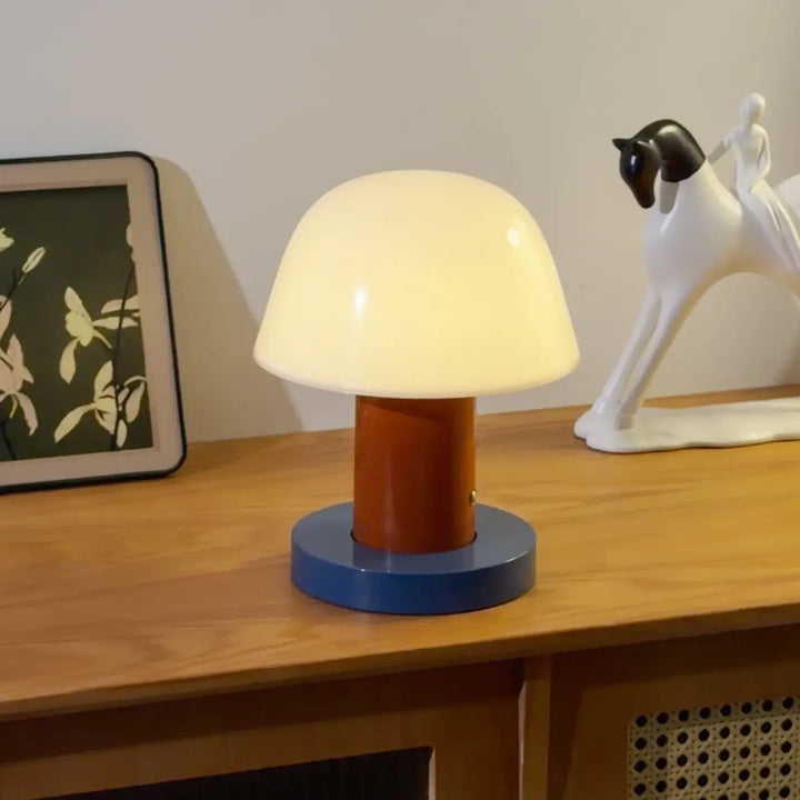 Lampe de table lithy en design champignon avec dôme translucide blanc chaud, tige orange et base bleue circulaire