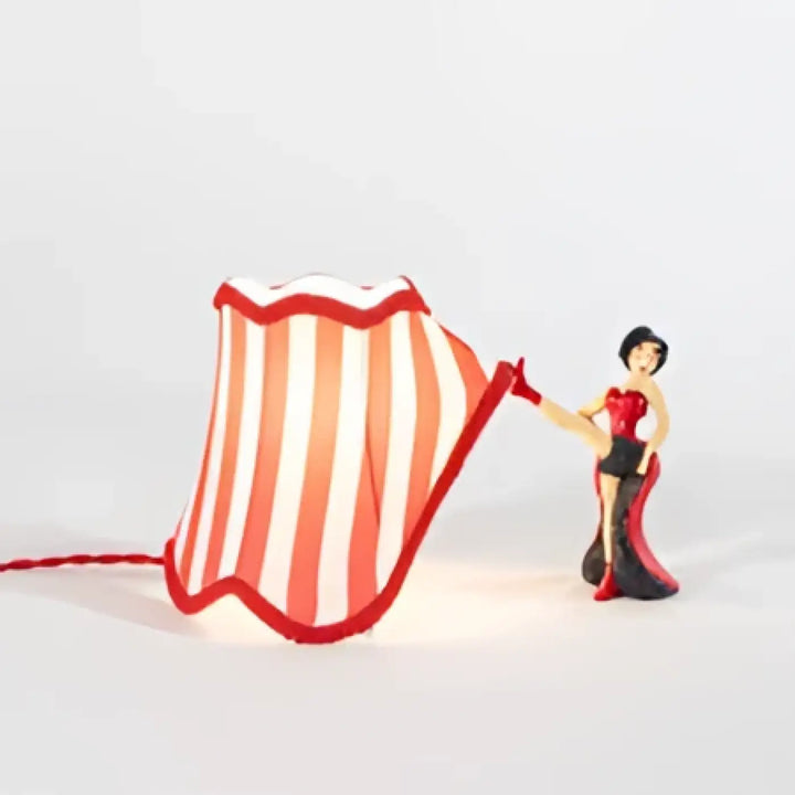 Lampe de table scène avec abat-jour rayé lumineux rouge et blanc à bord festonné, choix idéal pour table design