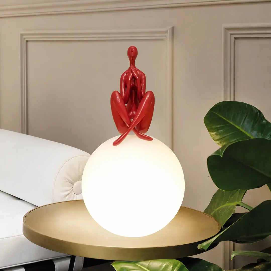 Lampe de table kelya avec silhouette enlacée rouge brillante sur base lumineuse sphérique pour un design moderne