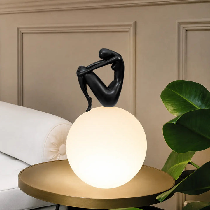 Lampe de table kelya avec silhouette enlacée noire perchée sur lumière sphérique pour un design de table contemporain