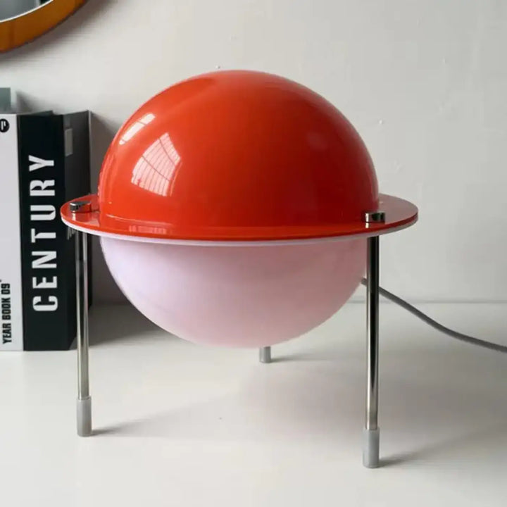 Lampe de table saturne rétro futuriste avec lumière chaleureuse en sphère rouge vif et rose pâle sur pieds chrome fins