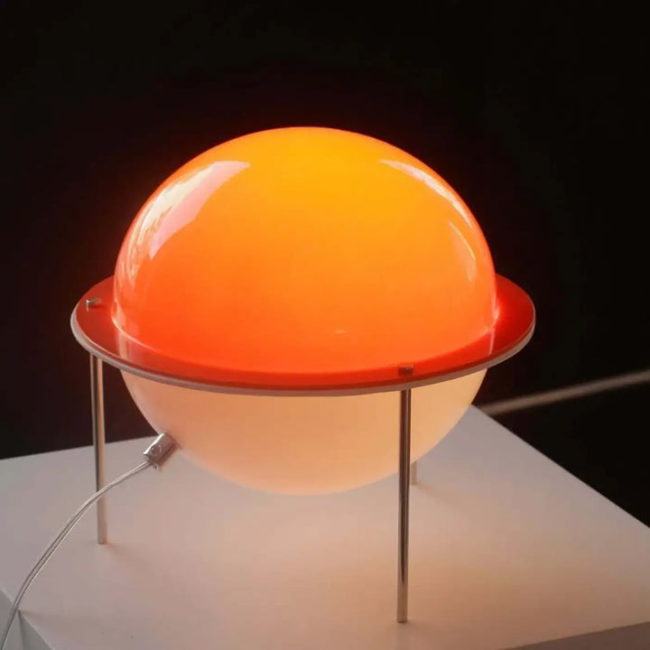 Lampe de table saturne globe translucide orange et blanc avec base métallique offrant une lumière chaleureuse rétro futuriste