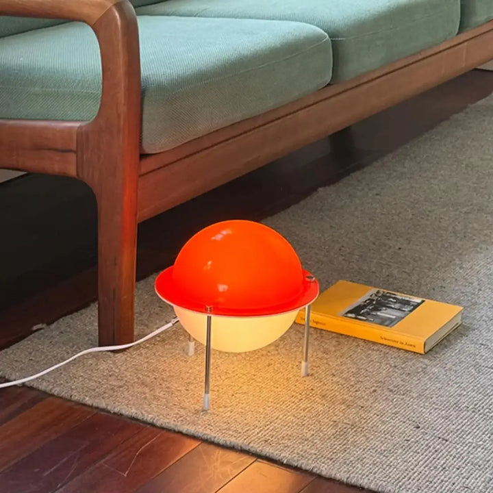 Lampe de table saturne rétro futuriste avec lumière chaleureuse en sphère orange jaune sur pieds métalliques fins