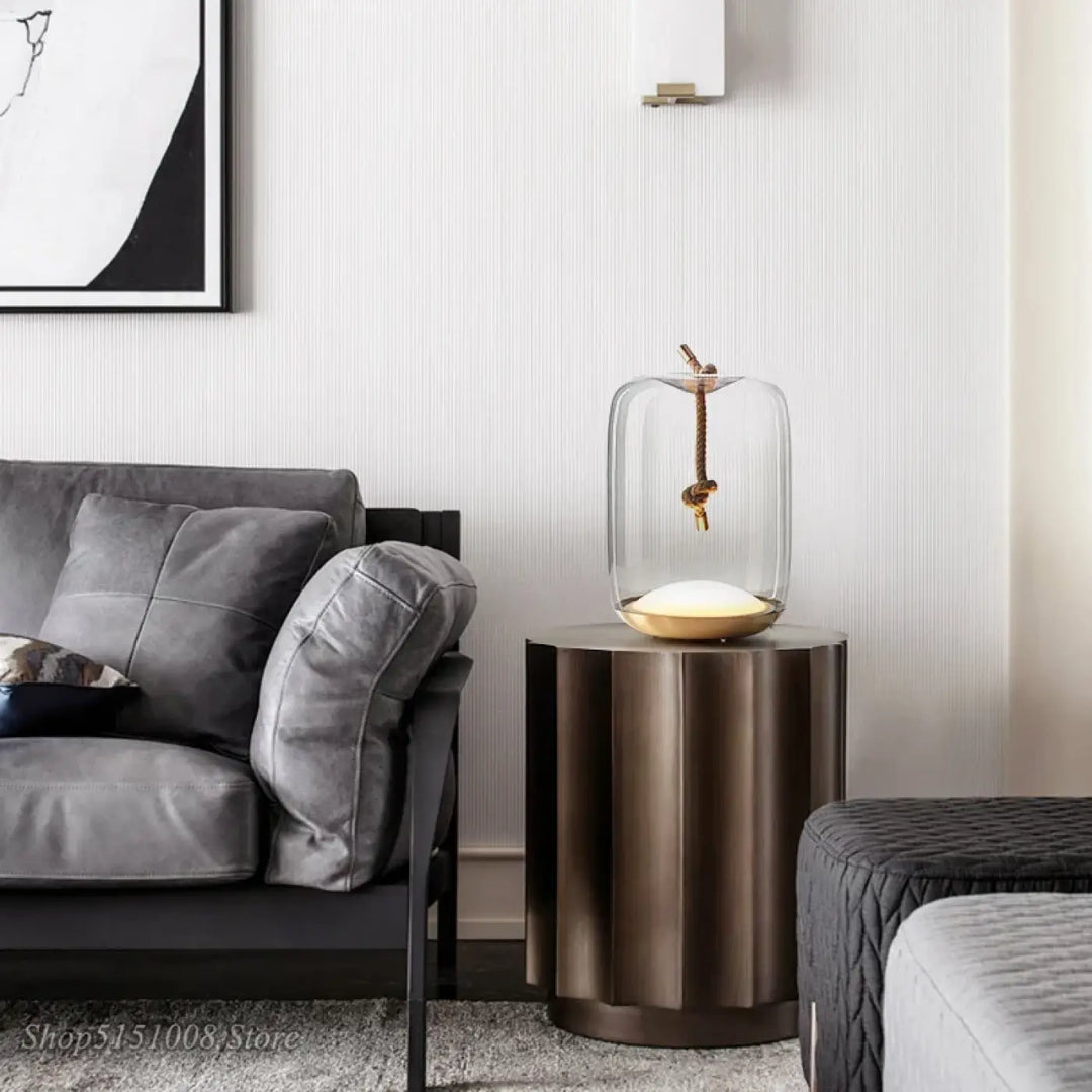 Lampe de table aeris en verre avec base dorée et corde suspendue pour une lumière douce en décoration intérieure moderne