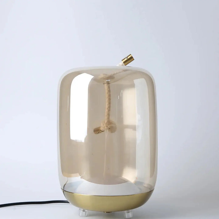 Lampe de table aeris en verre ambre translucide avec base et capuchon en laiton pour une lumière douce et décoration intérieure moderne