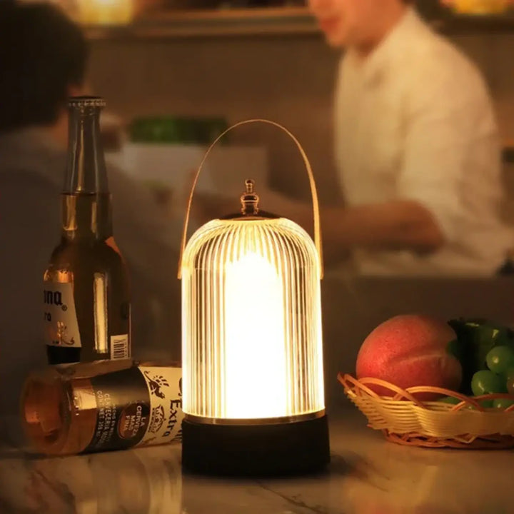 Lampe de table moderne à l’esprit lanterne avec corps en verre nervuré et anse en laiton chaleureux et éclairant