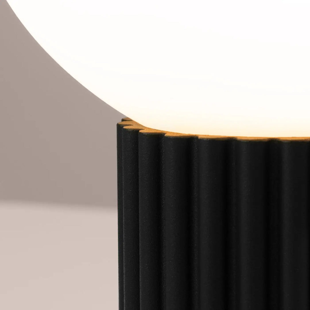 Lampe a poser halo noir avec base nervurée noire et abat-jour sphérique en verre laiteux pour réponse aux besoins design