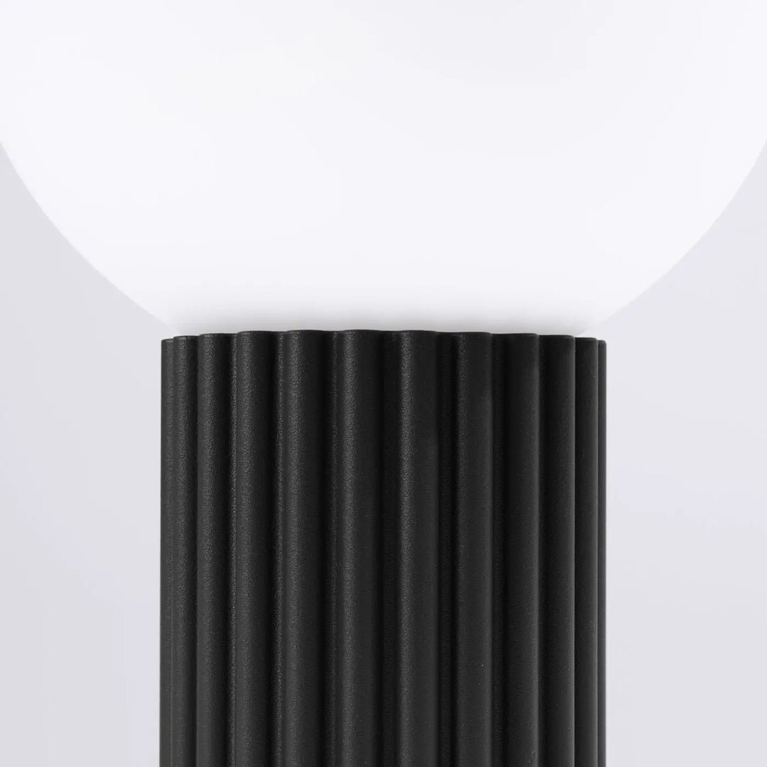 Lampe a poser halo noir avec base noire côtelée et abat-jour sphérique en verre laiteux réponse aux besoins design élégant