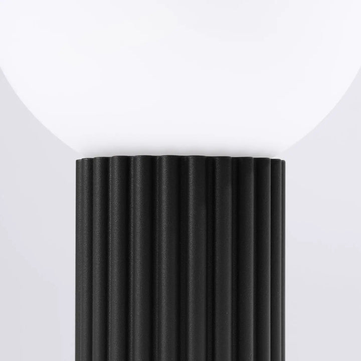 Lampe a poser halo noir avec base noire côtelée et abat-jour sphérique en verre laiteux réponse aux besoins design élégant