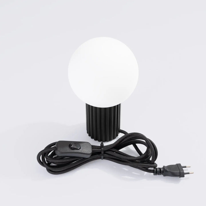 Lampe à poser halo noir avec verre laiteux sphérique et base nervurée en résine noire avec cordon en spirale