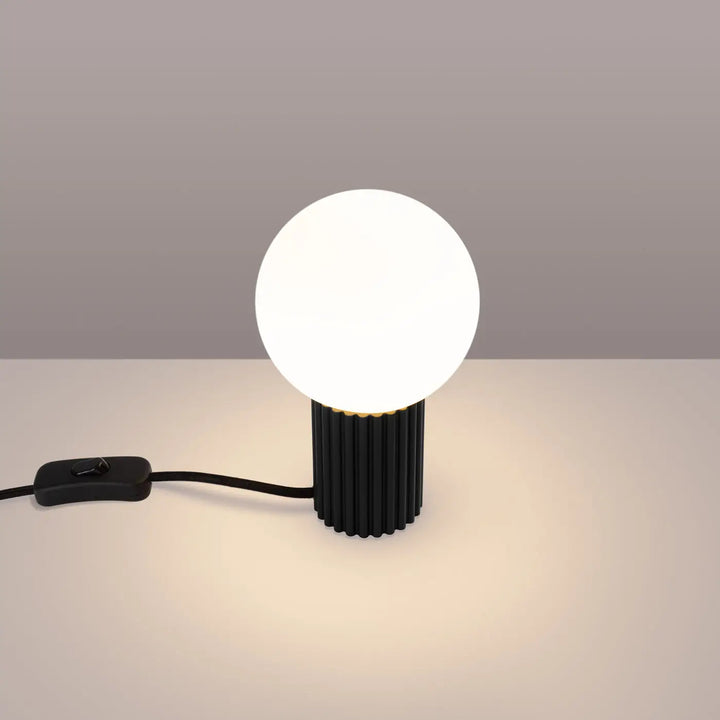Lampe à poser halo noir avec base cylindrique striée en verre laiteux et abat-jour sphérique blanc pour réponse aux besoins d’éclairage