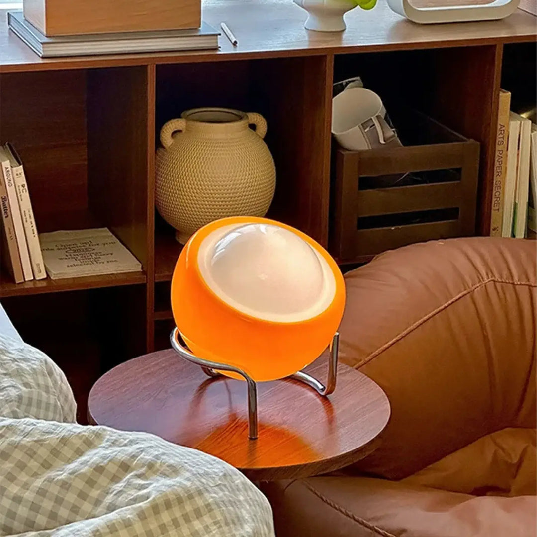 Lampe de table orya orange sphérique avec diffuseur opalin blanc et pieds chromés pour table design moderne