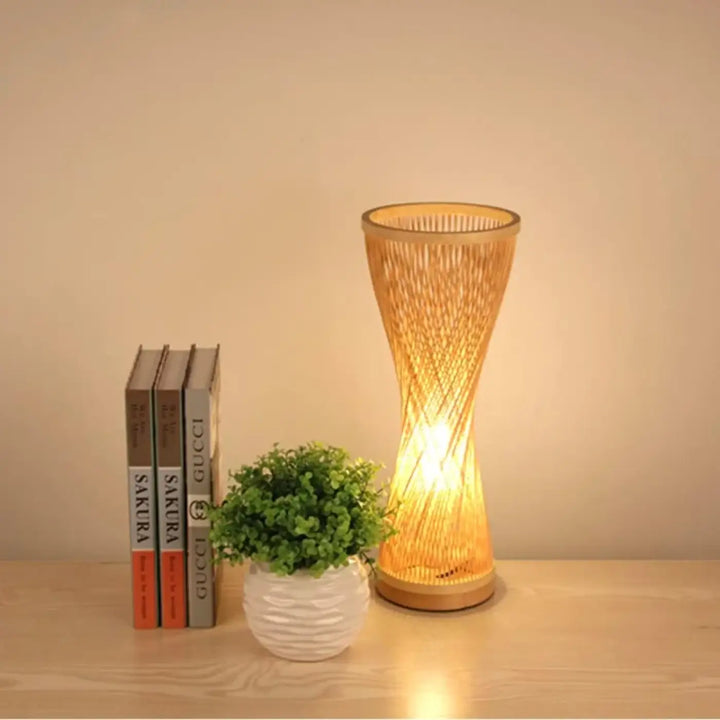 Lampe de table musa en rotin naturel tressé avec lumière douce et design en bambou torsadé sur socle circulaire