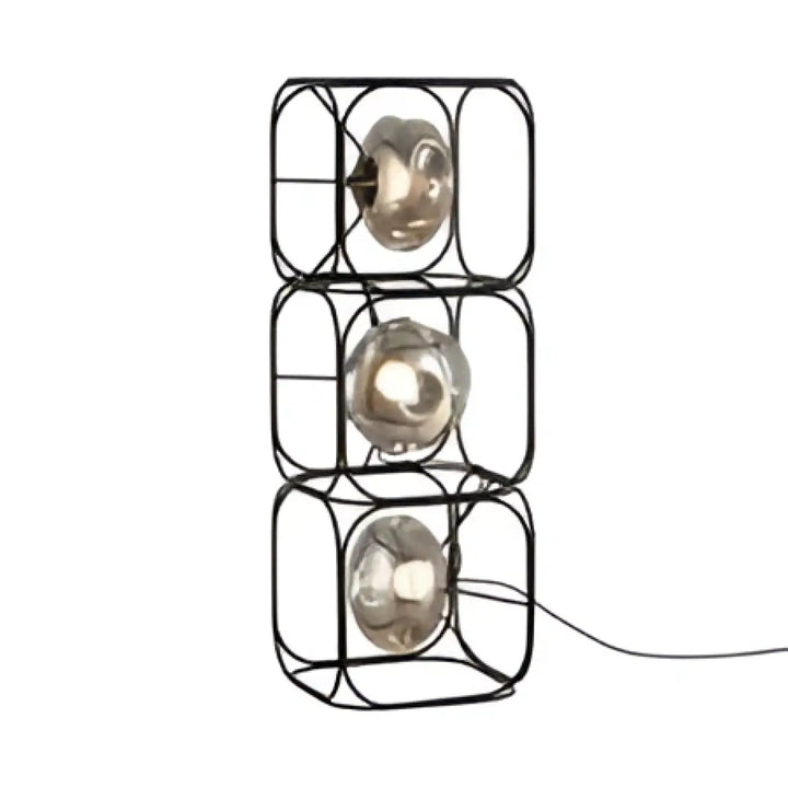 Lampe de table haloza en cube metal noir avec trois sphères lumineuses en verre empilées pour un table design sculptural