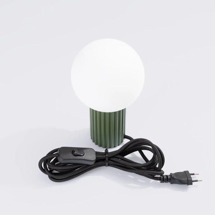 Lampe à poser halo vert olive avec base cannelée en vert olive, abat-jour sphérique en verre dépoli blanc et cordon noir