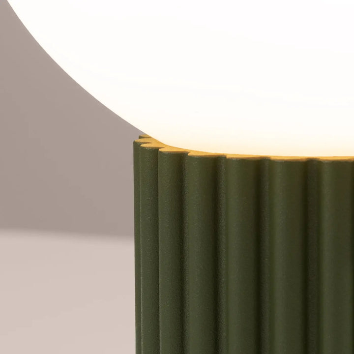 Lampe à poser halo vert olive en céramique rainurée avec abat-jour sphérique blanc diffusant une lumière douce