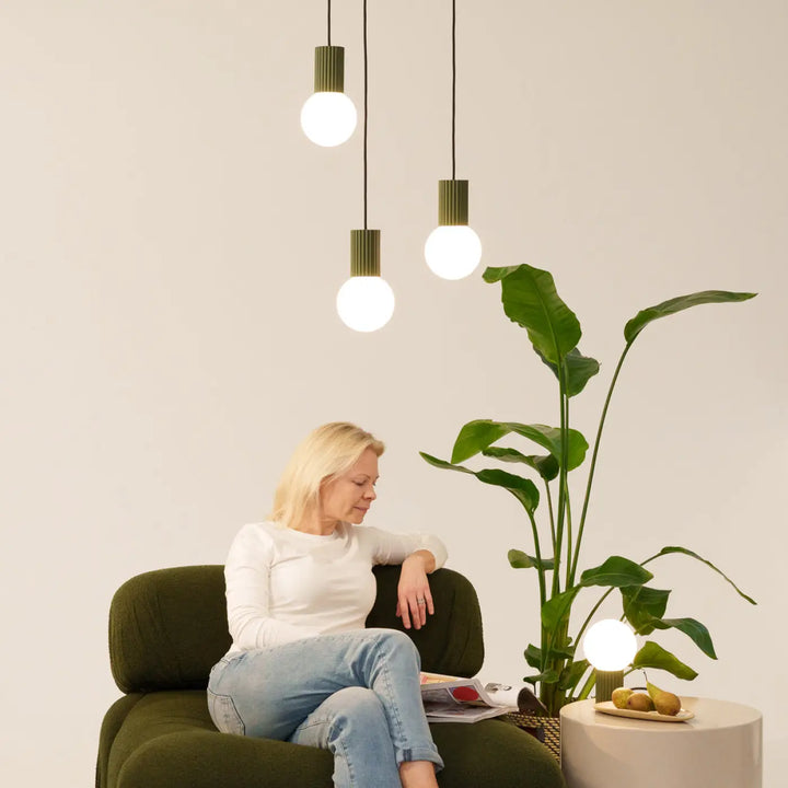Trois suspensions halo vert olive avec abat-jours côtelés posés en lampe à poser version suspension