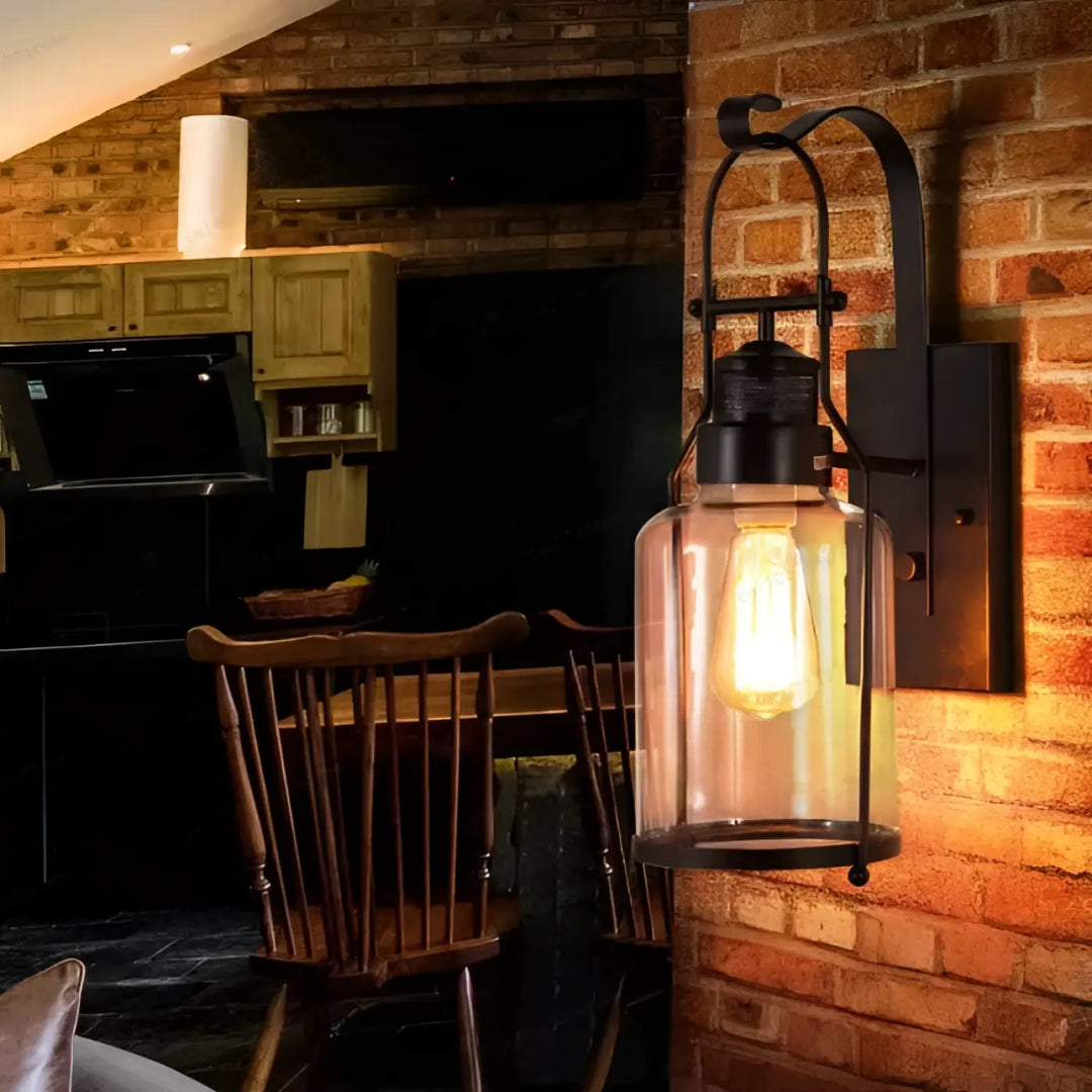 Luminaire extérieur orsina en fer forgé noir avec design raffiné et ampoule filament visible dans un verre transparent