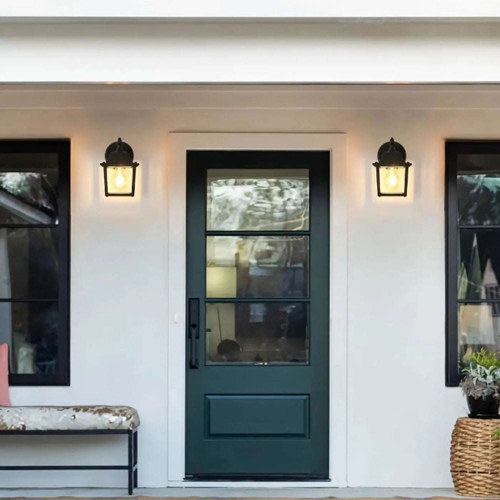 Luminaire extérieur héris avec lanterne traditionnelle en verre clair sur porte d entrée vert foncé encadrée de noir