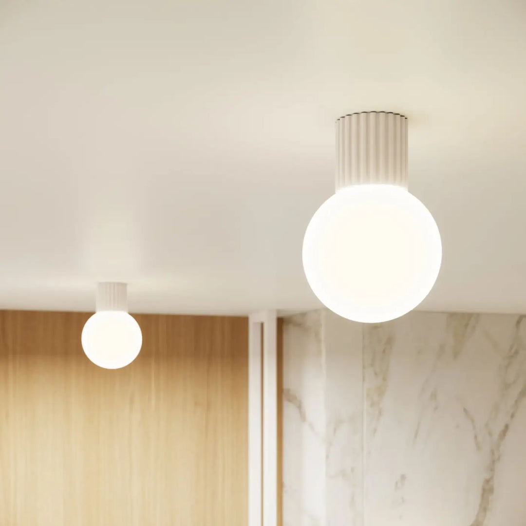 Luminaire plafonnier halo beige avec sphère laiteuse et base cylindrique nervurée pour bureau décorative