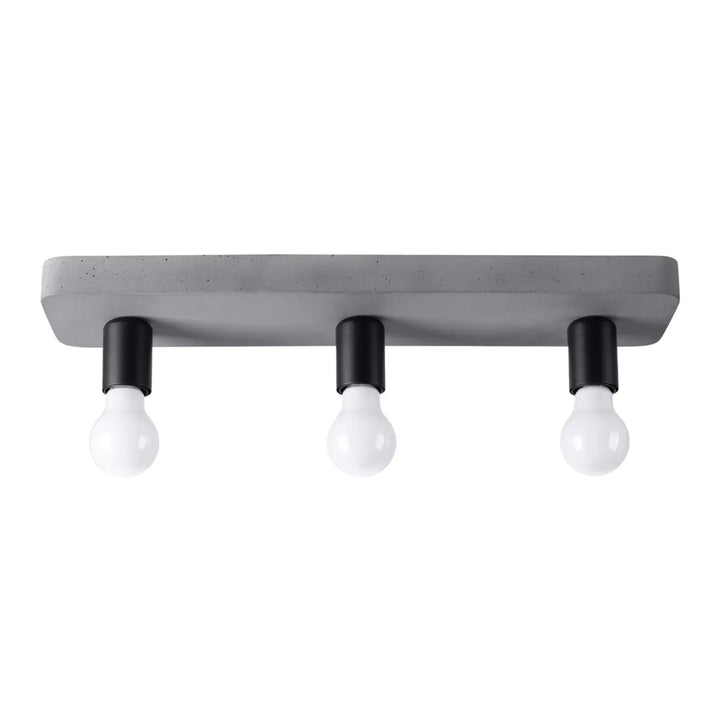 Plafonnier tavo l’esthétique moderne avec finition gris béton, trois supports noirs pour ampoules en verre clair créant une ambiance unique